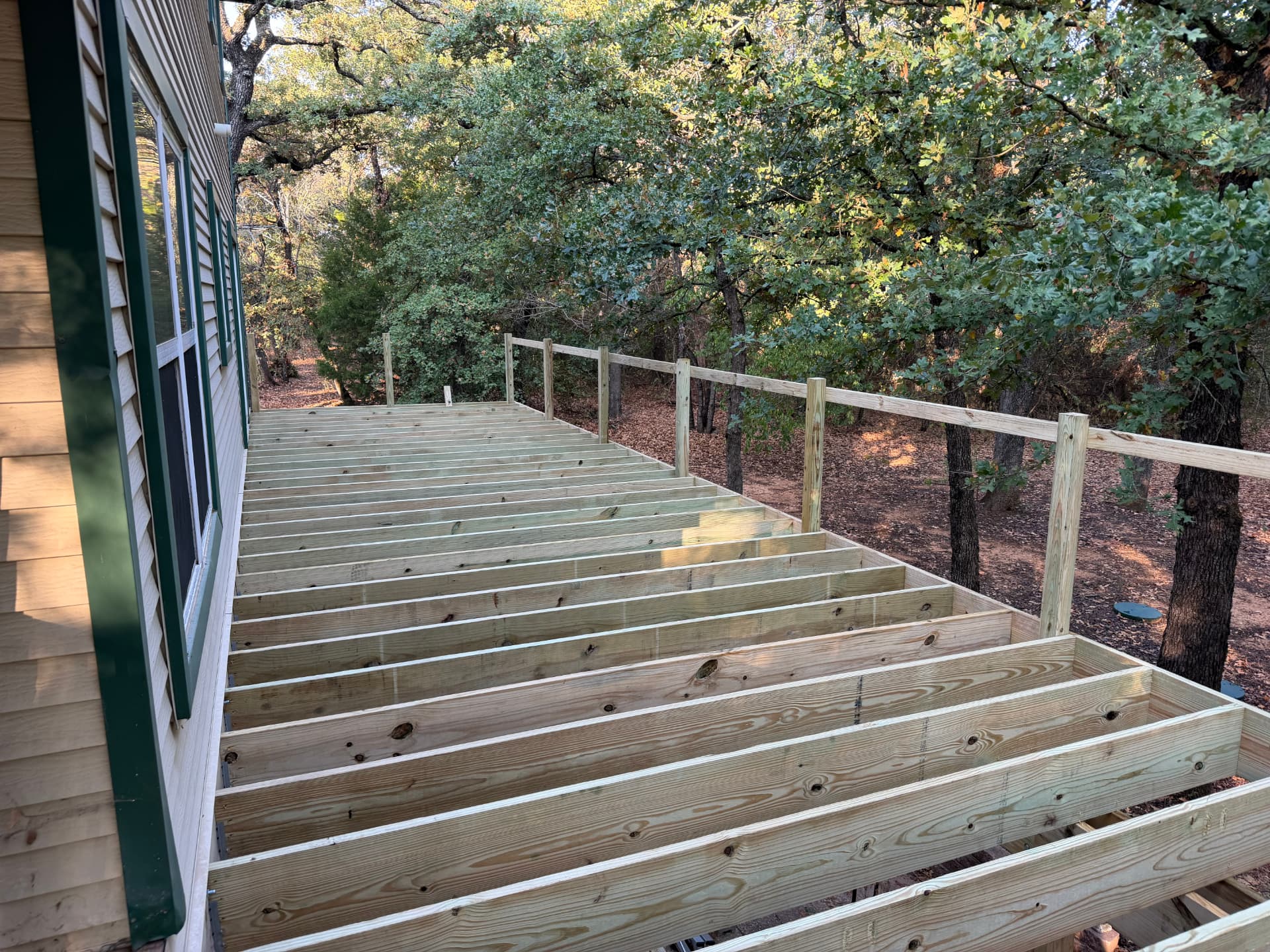 Deck joists and rail posts installed along the back of Greg's Grandview, TX home, ready for composite decking