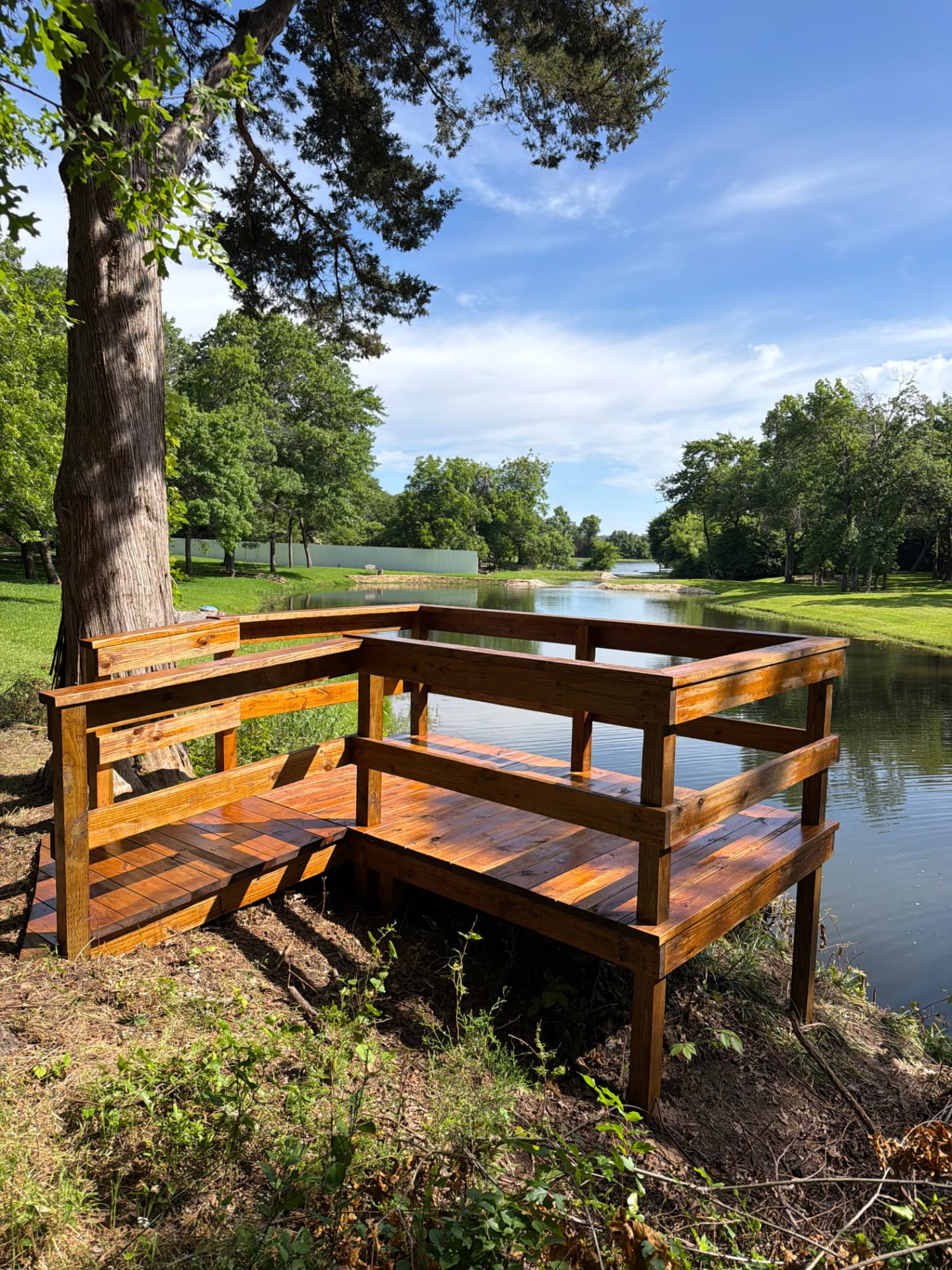 Freshly stained wooden deck by a pond