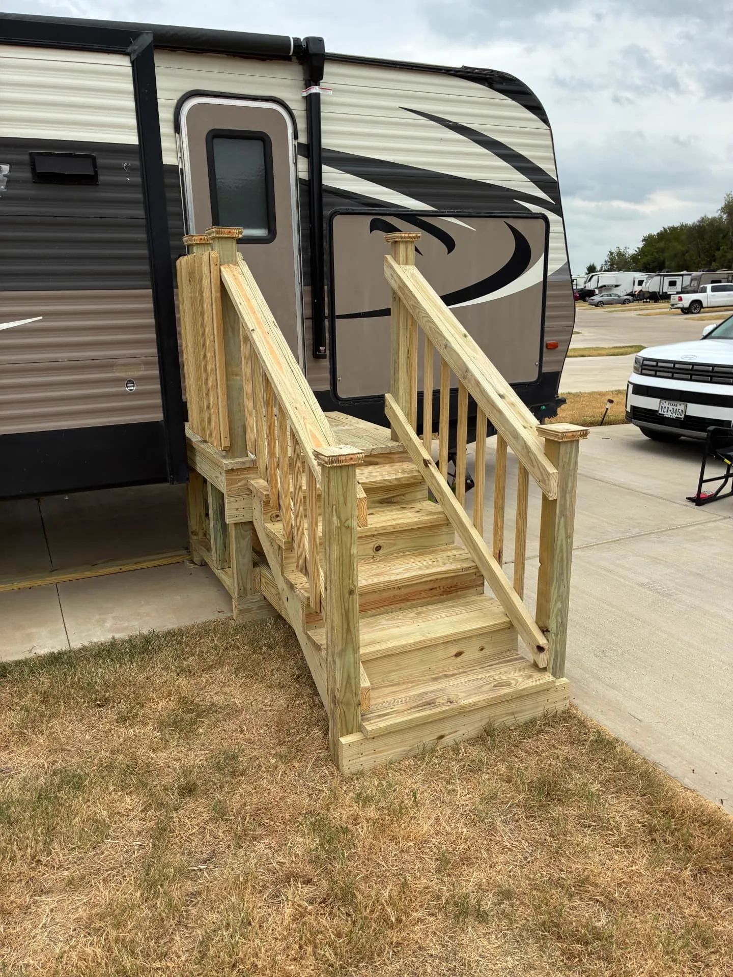 Side view of a 4x4 treated wood RV deck with spindle railing and post caps, built by BenchMark Decks in Burleson, Texas