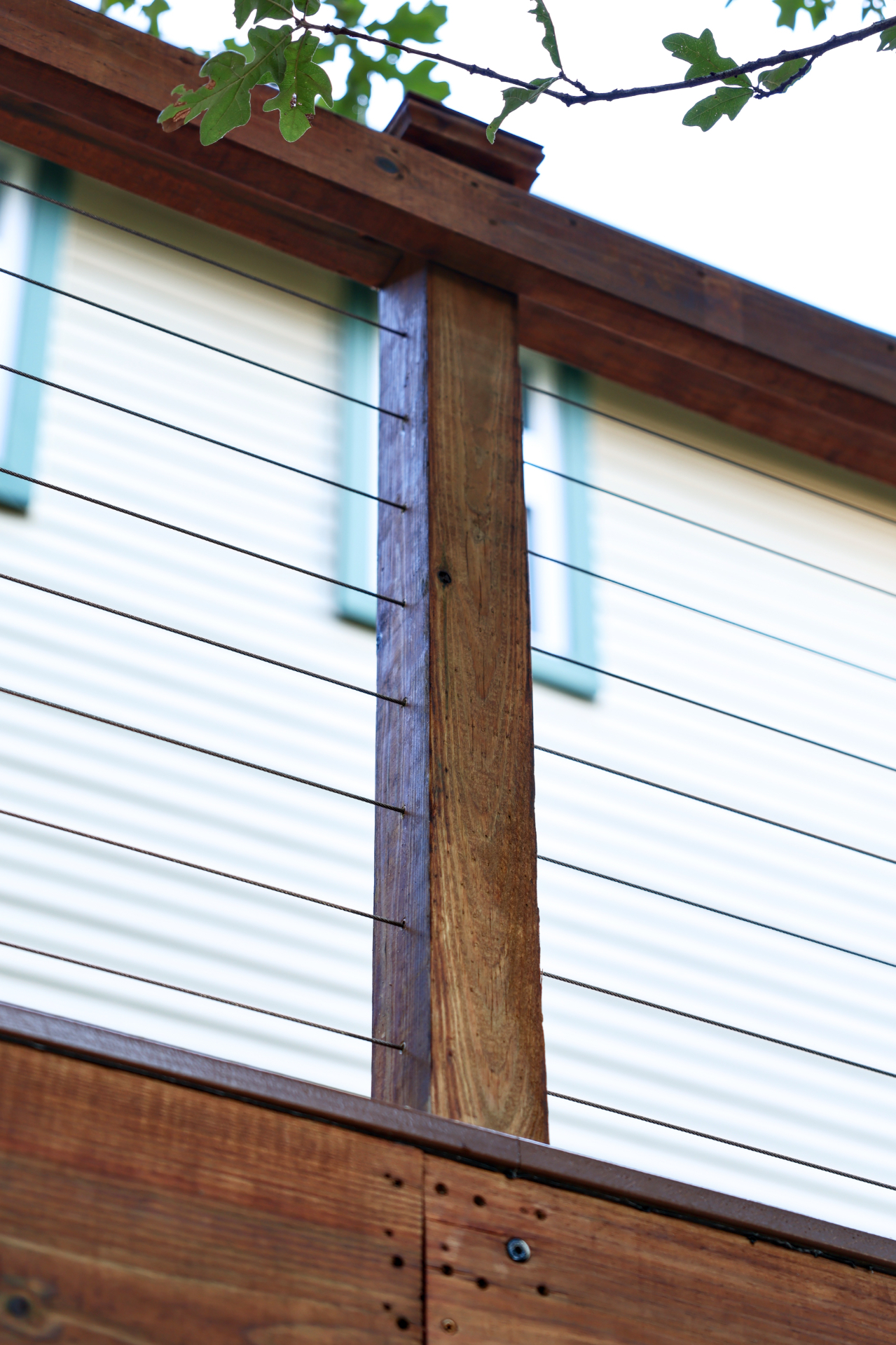 Stainless cable railing runs tensioned between stained wood posts on Greg's Grandview, TX deck