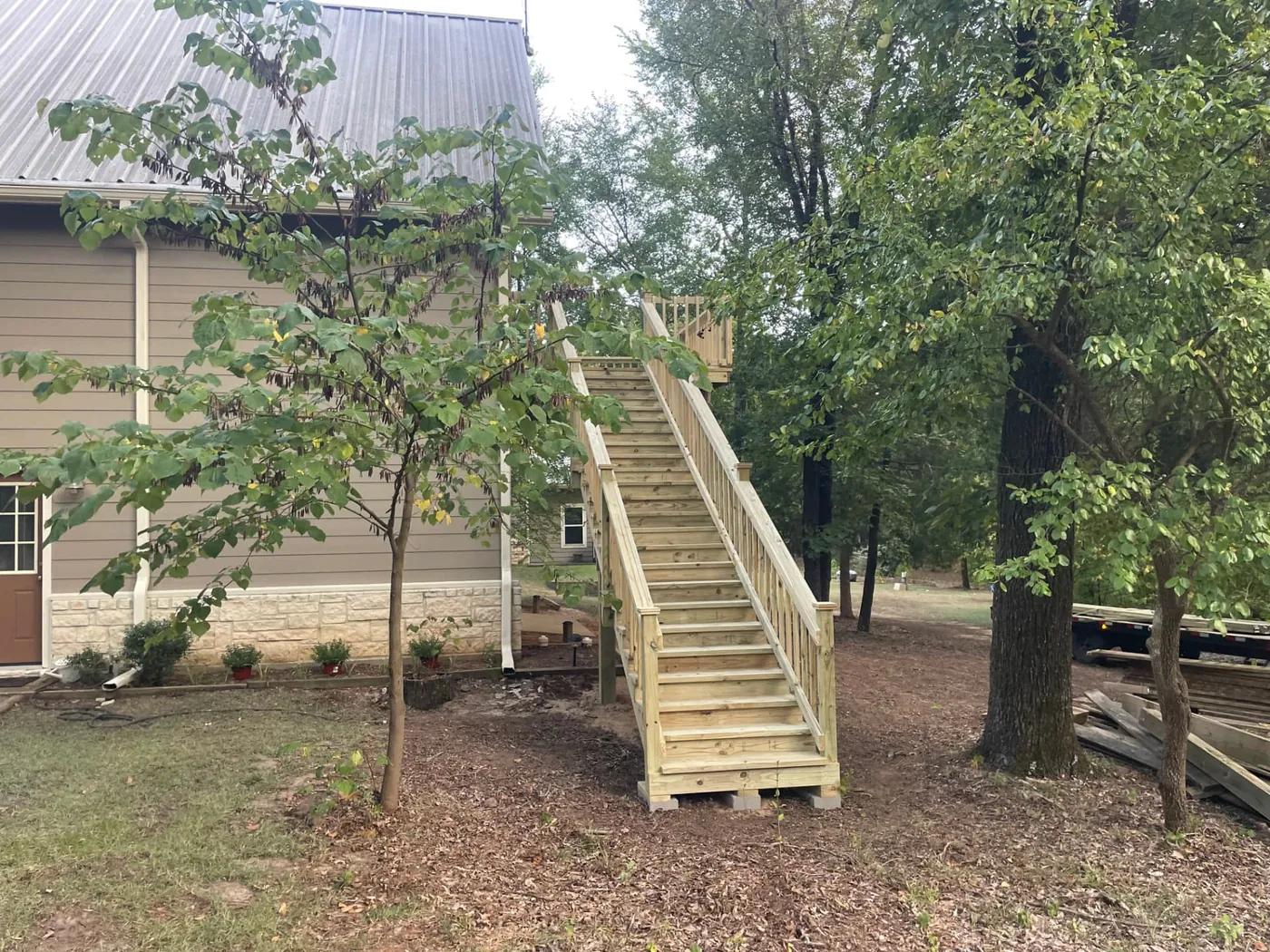 Tall pressure-treated stair run to a second-story deck