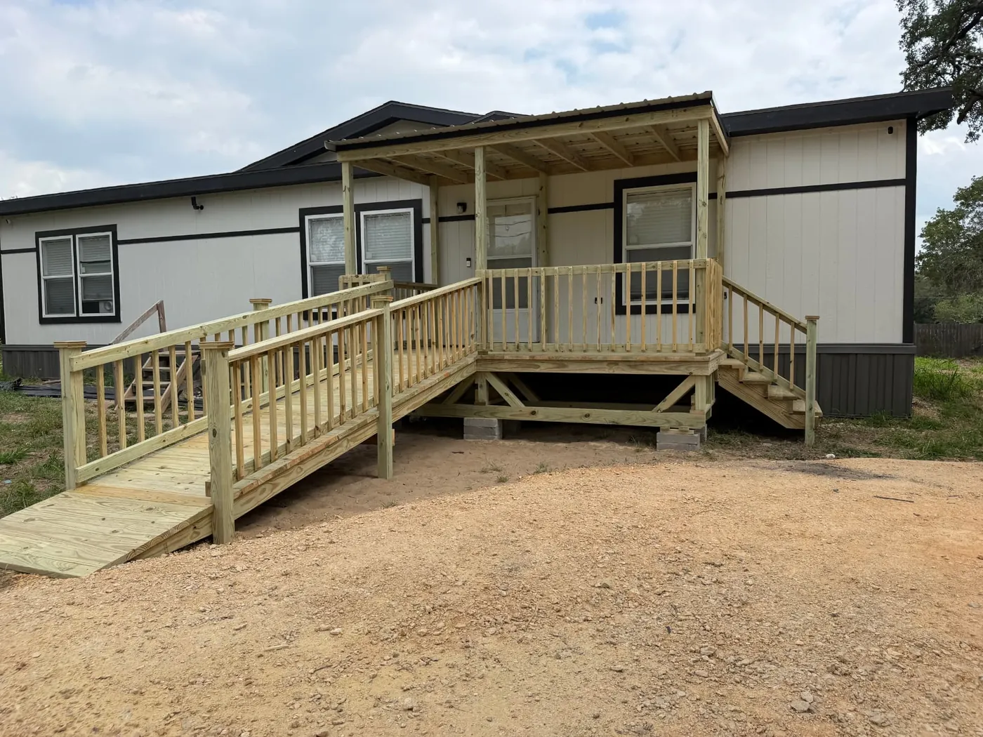 Covered mobile home porch deck with railing and long access ramp
