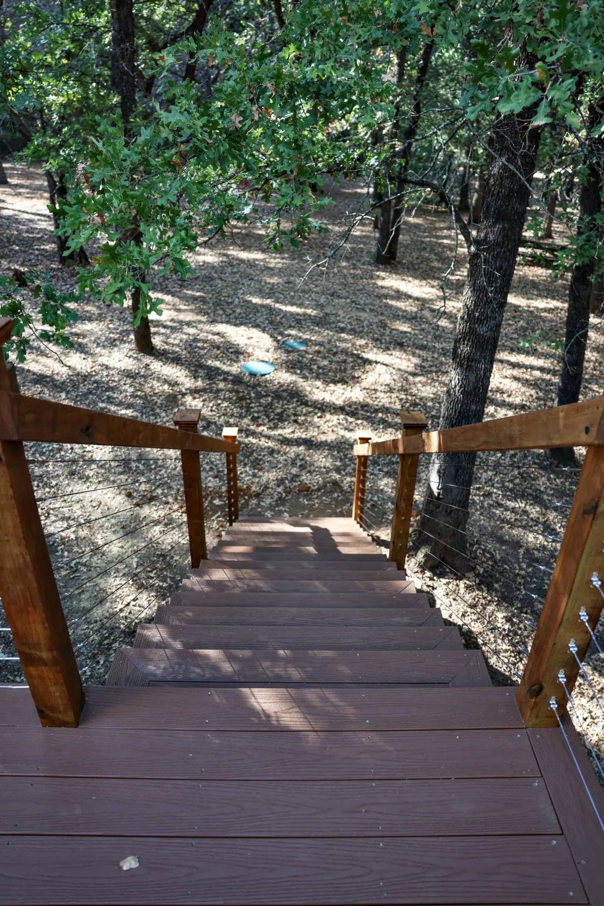 Composite deck stairs with cedar posts and cable railing