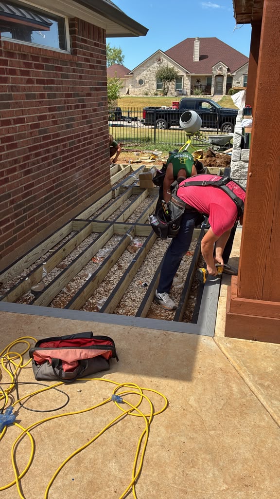 Crew fastening the first composite boards to Chase's deck frame