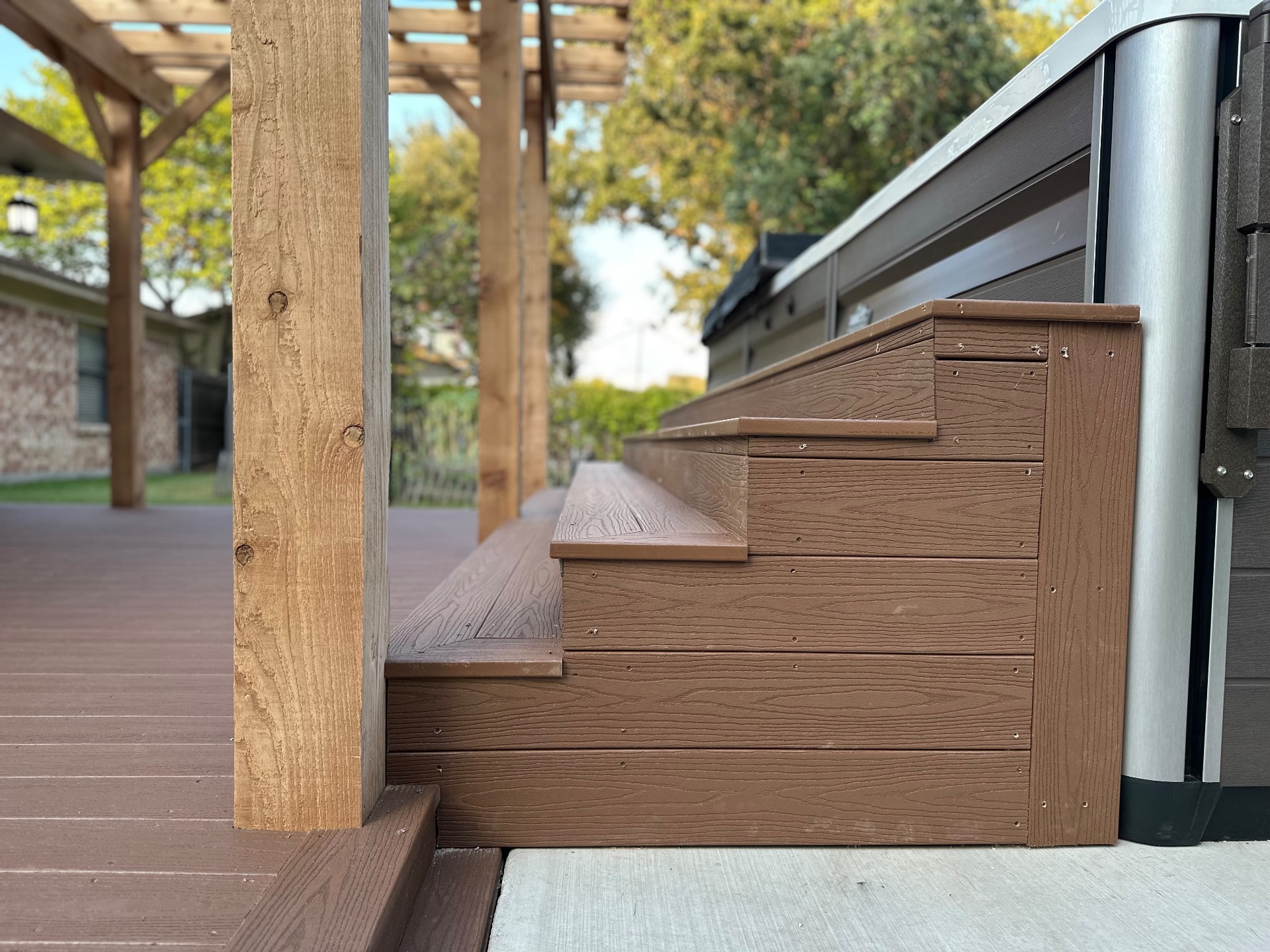 Close view of the wrapped composite steps beside the pool spa on Danny's deck