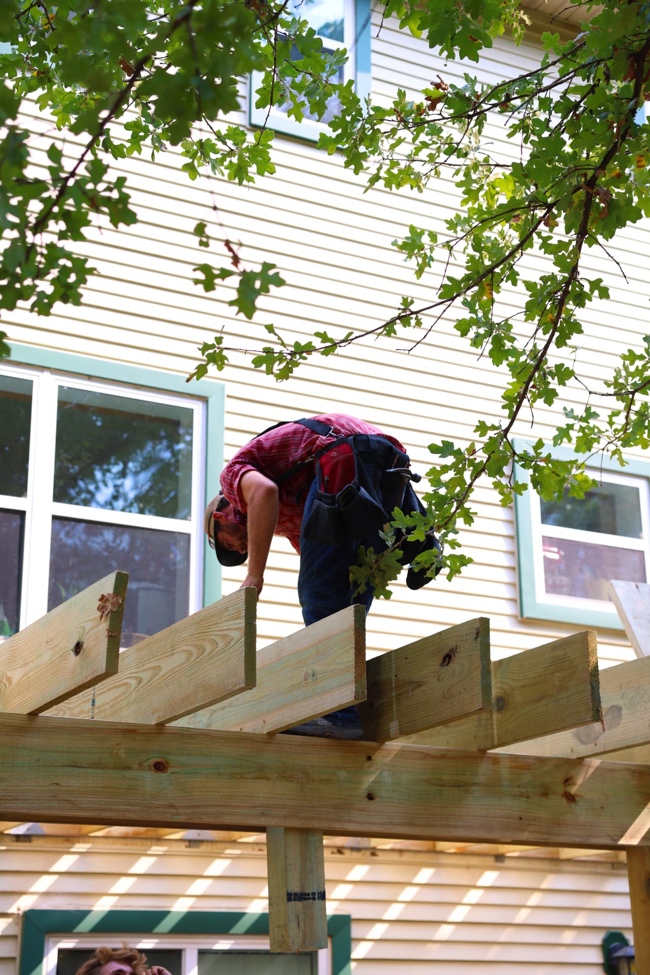 Crew member setting deck joists on top of the beam framing