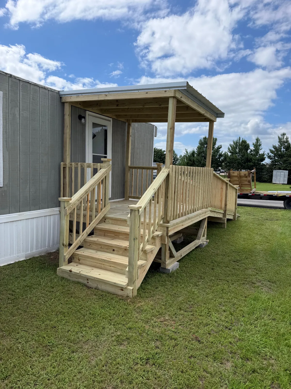 Covered 8x8 entry deck with steps, handrails and Galvalume roof, built by BenchMark Decks in Tyler, Texas