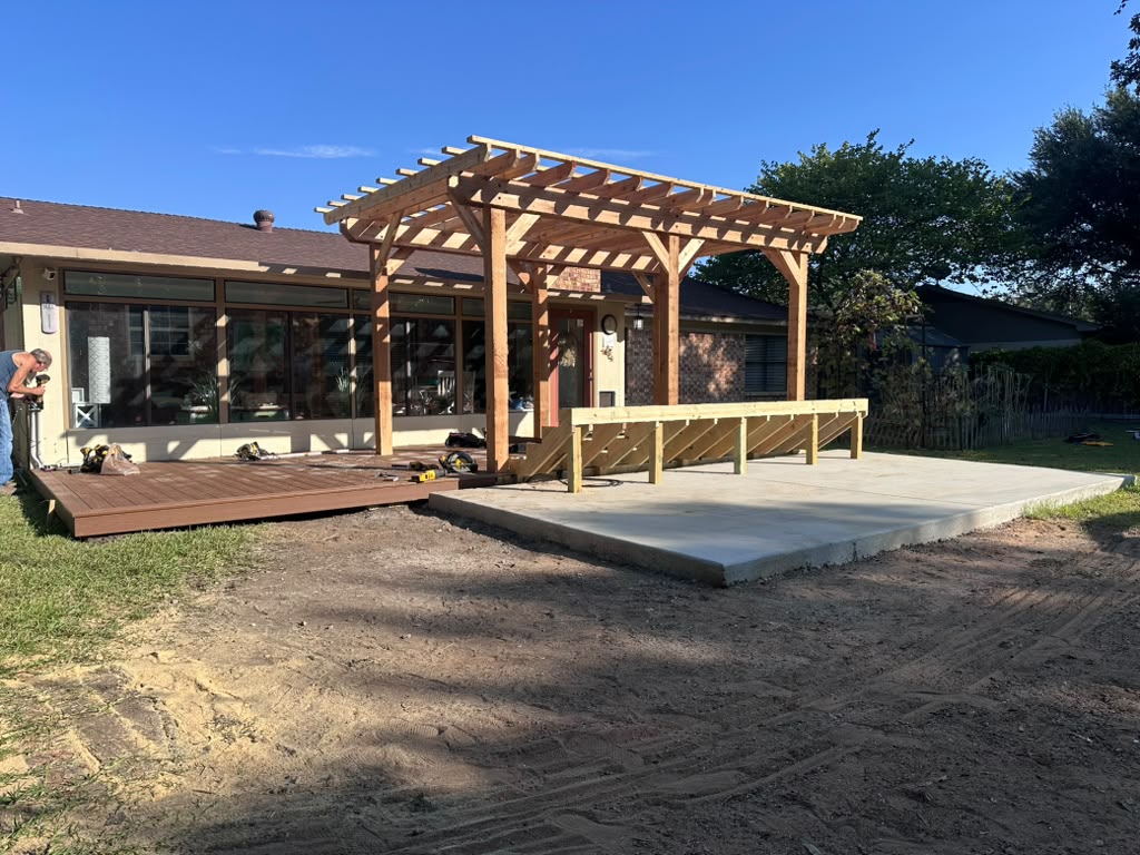 Danny's finished cedar pergola with most of the composite decking installed next to the new concrete pad