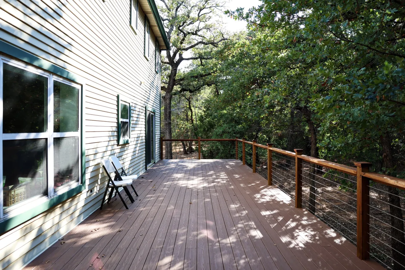 Composite deck with cable railing overlooking wooded lot