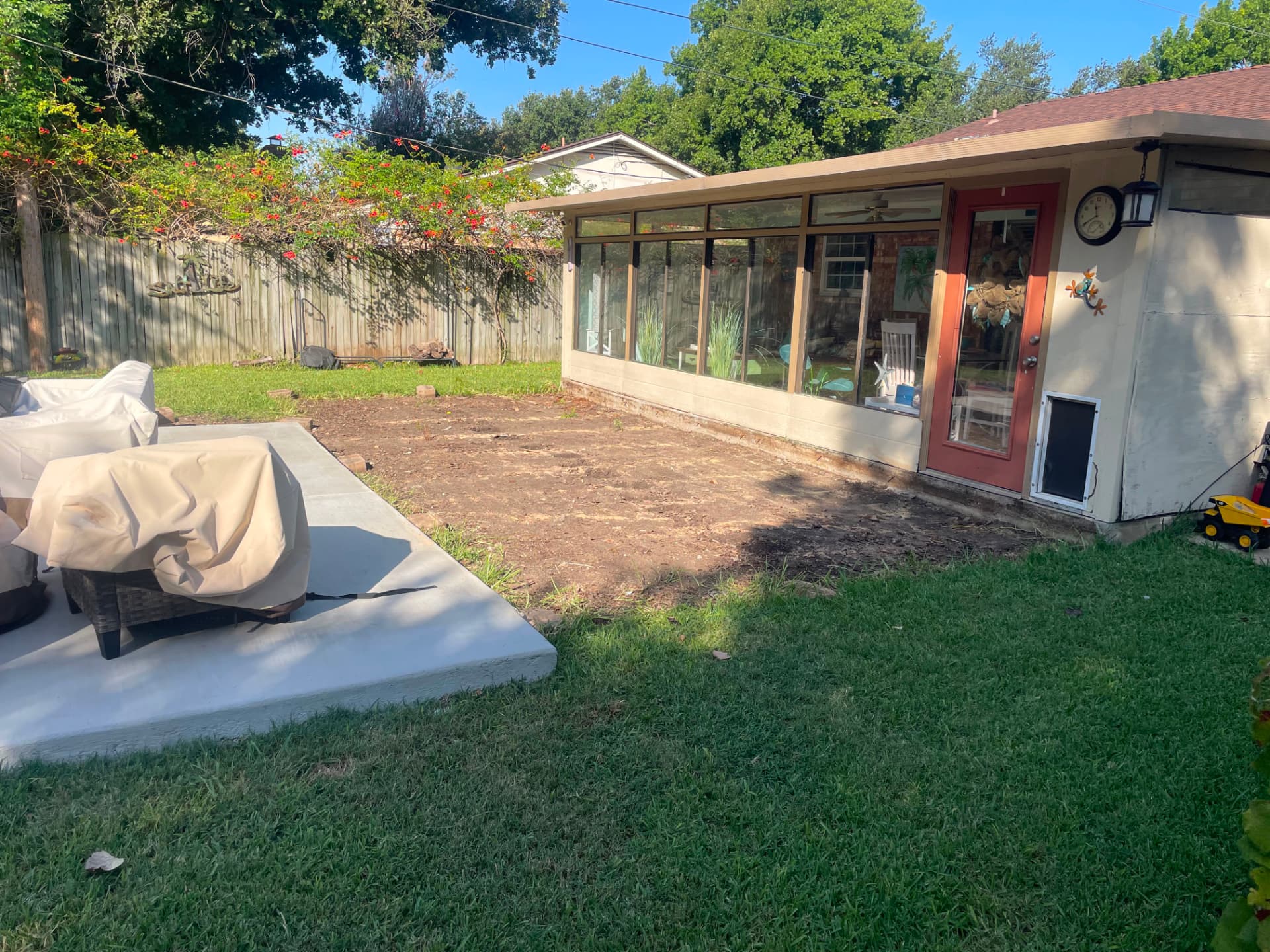 Danny's backyard after the old deck was torn out, bare dirt along the sunroom