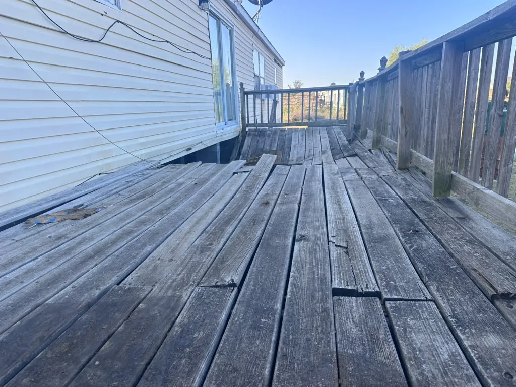 Split and rotted deck boards on the old deck surface