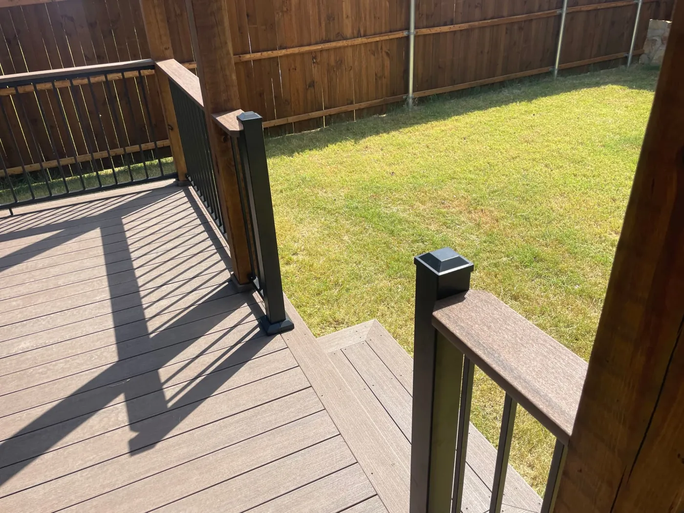 Composite deck boards with black aluminum railing and post caps