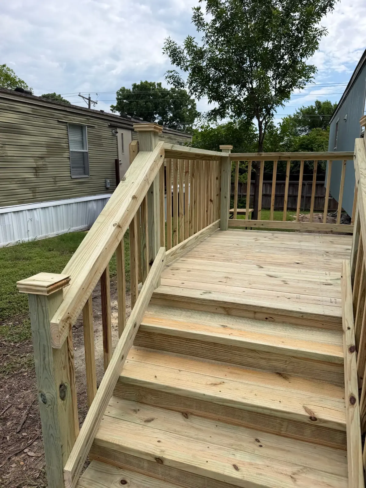 Pressure-treated mobile home deck with railing and stair run