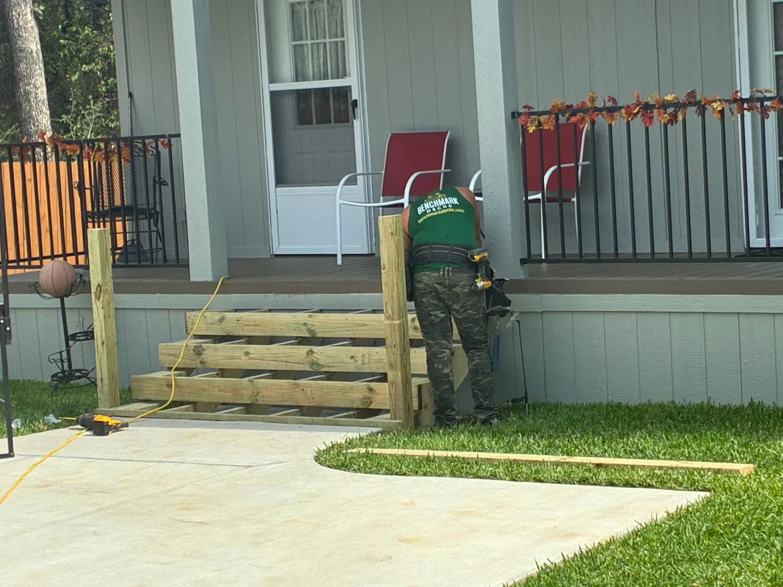 Crew building 8 foot wide composite steps at a front porch, built by BenchMark Decks in Fort Worth, Texas