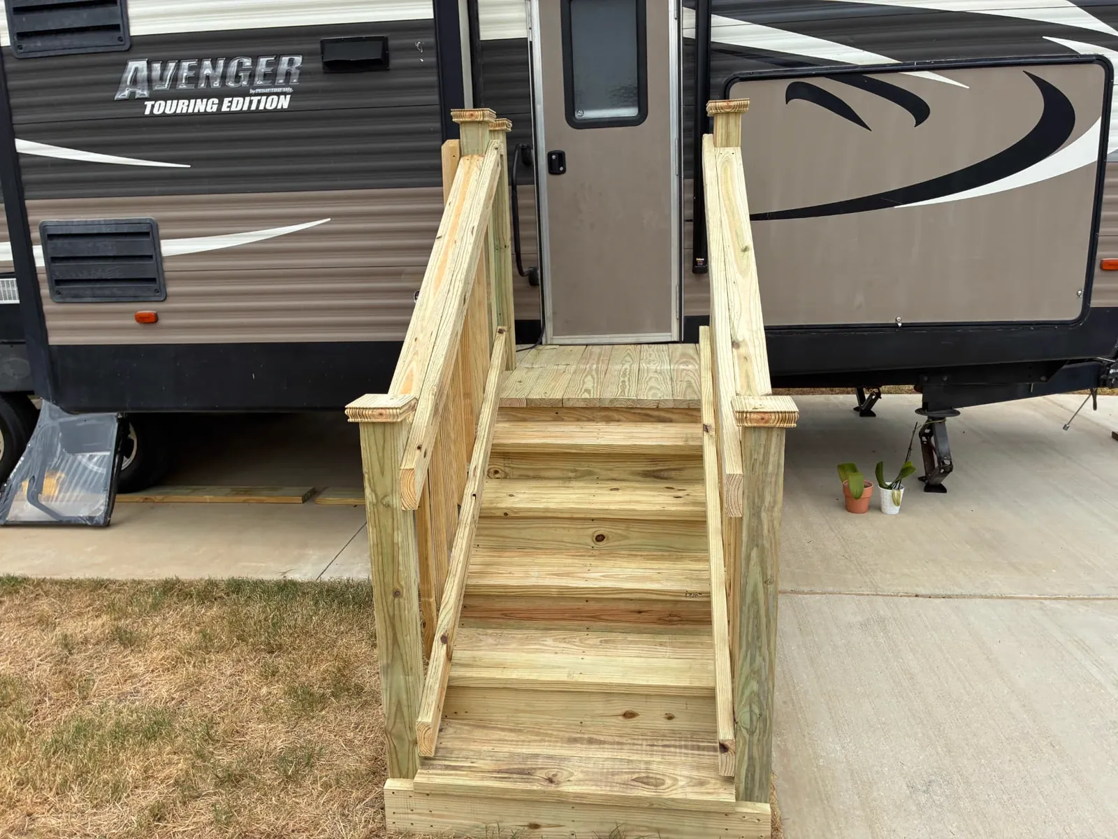 Pressure treated steps with handrails leading up to a 4x4 landing at an RV door, built by BenchMark Decks in Burleson, Texas