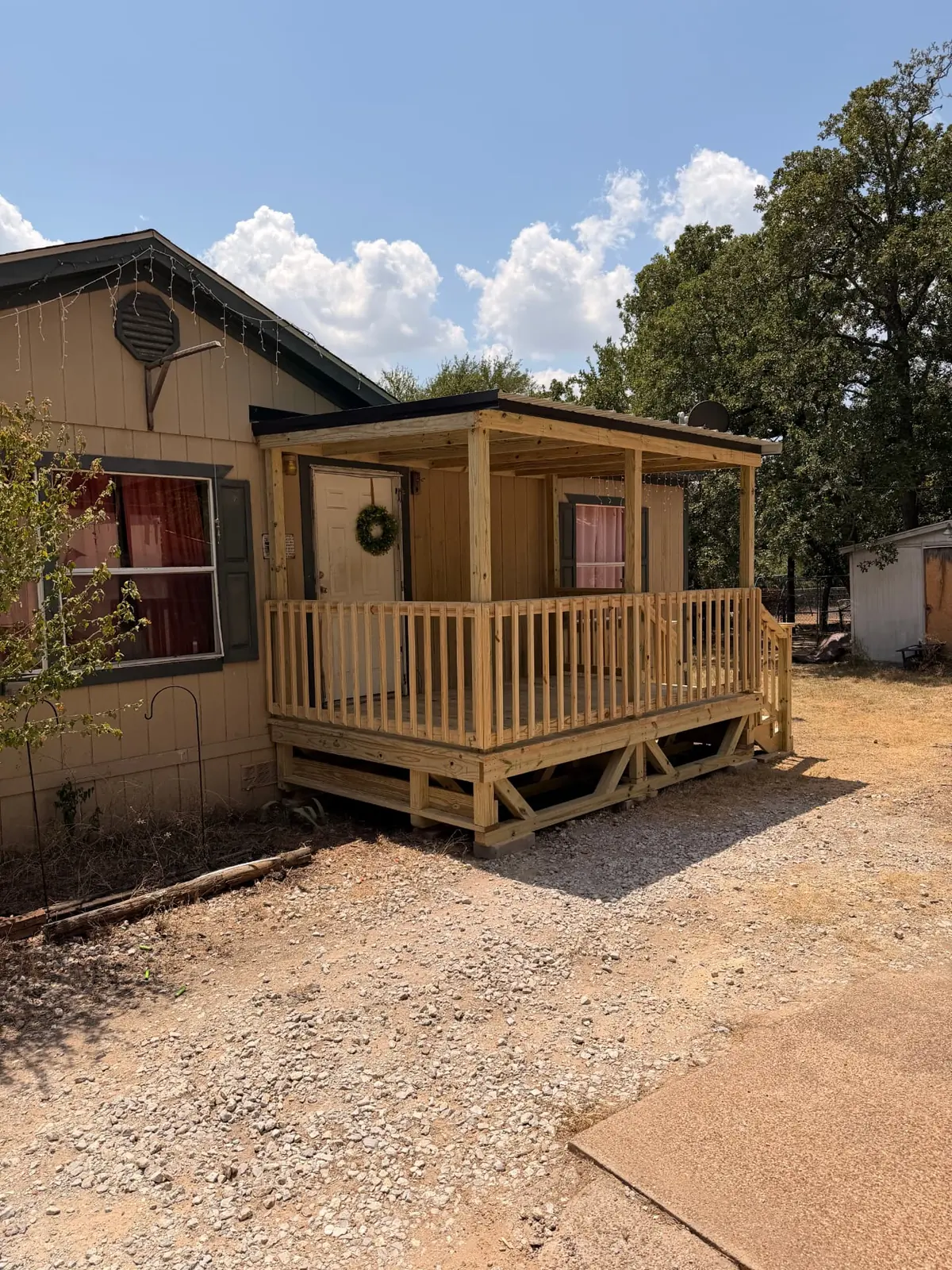 Covered porch deck with railing and metal roof on a mobile home