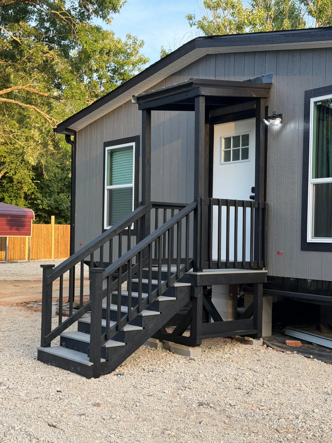 Black-stained deck with composite treads and stairs on a modern manufactured home