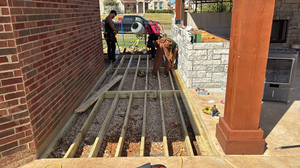 Crew setting pressure treated joists over the gravel pad on Chase's deck