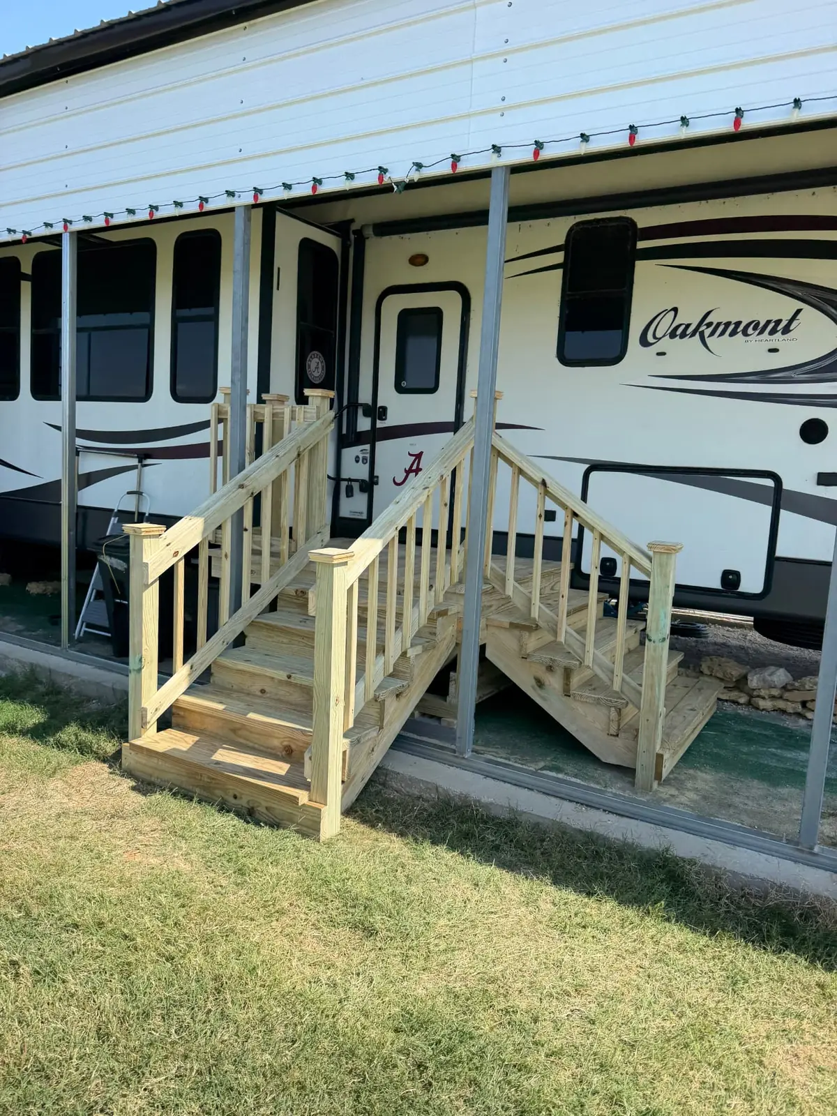 Wooden RV entry deck with dual stair runs under a covered RV site