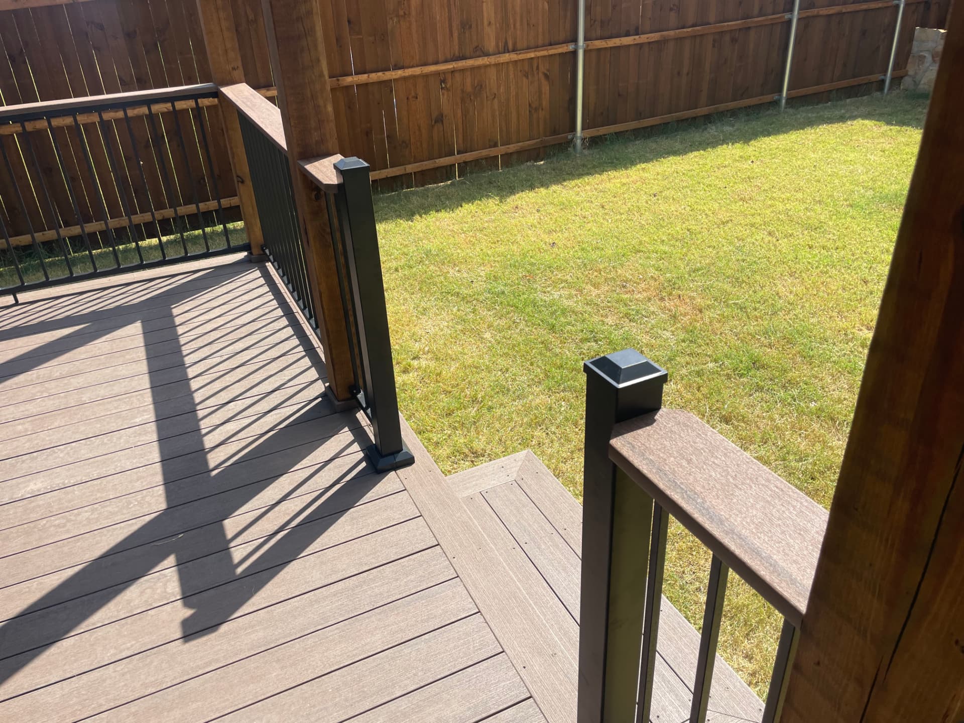 Composite deck boards with black aluminum railing and post caps