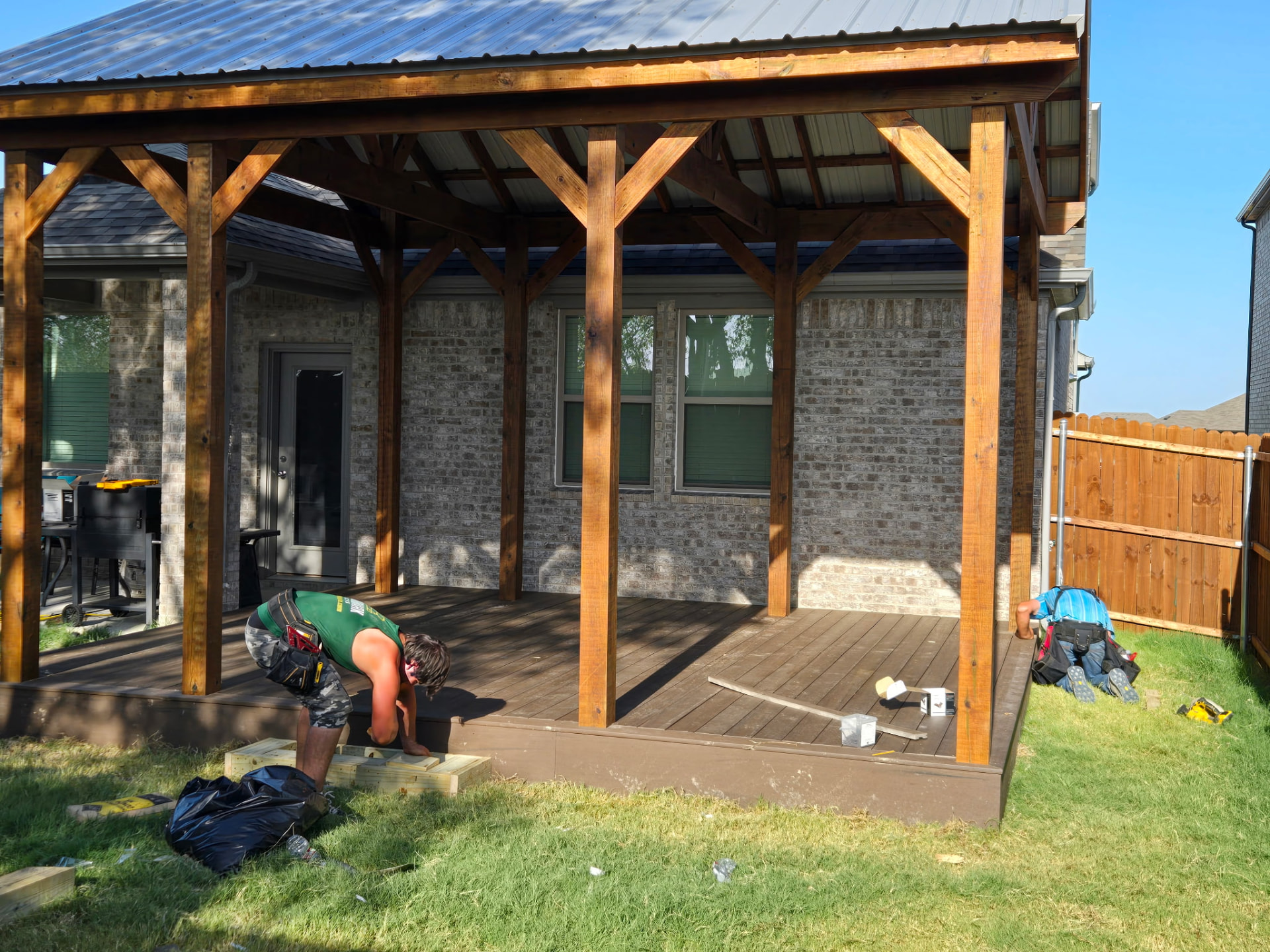 Crew installing composite decking under the new timber pavilion