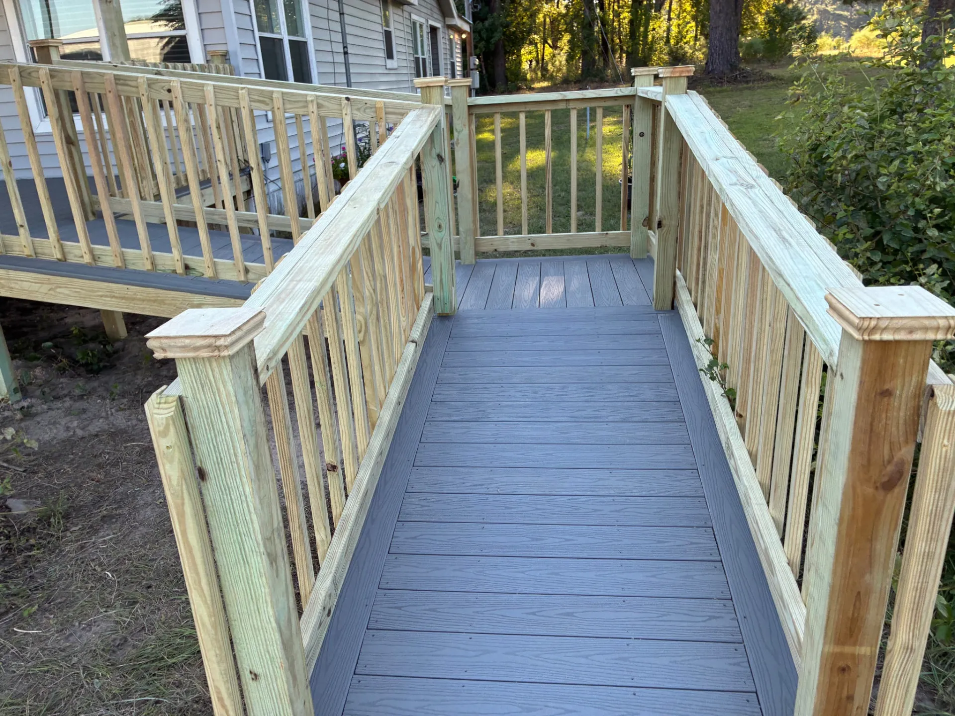 Ramp switchback landing with composite decking and post caps, built by BenchMark Decks in Trinity, Texas