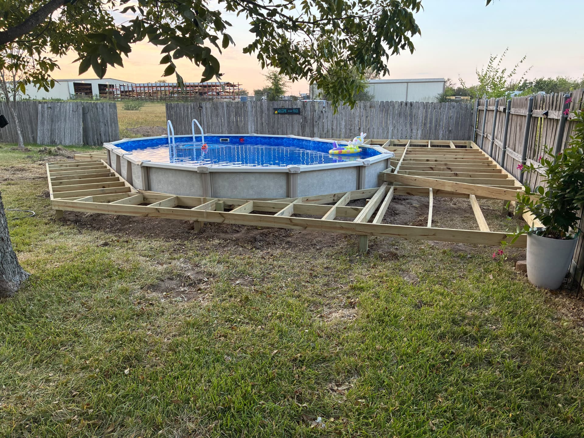 Pressure treated deck framing wrapping around an above-ground pool in Terri's backyard, built by BenchMark Decks in Mabank, Texas
