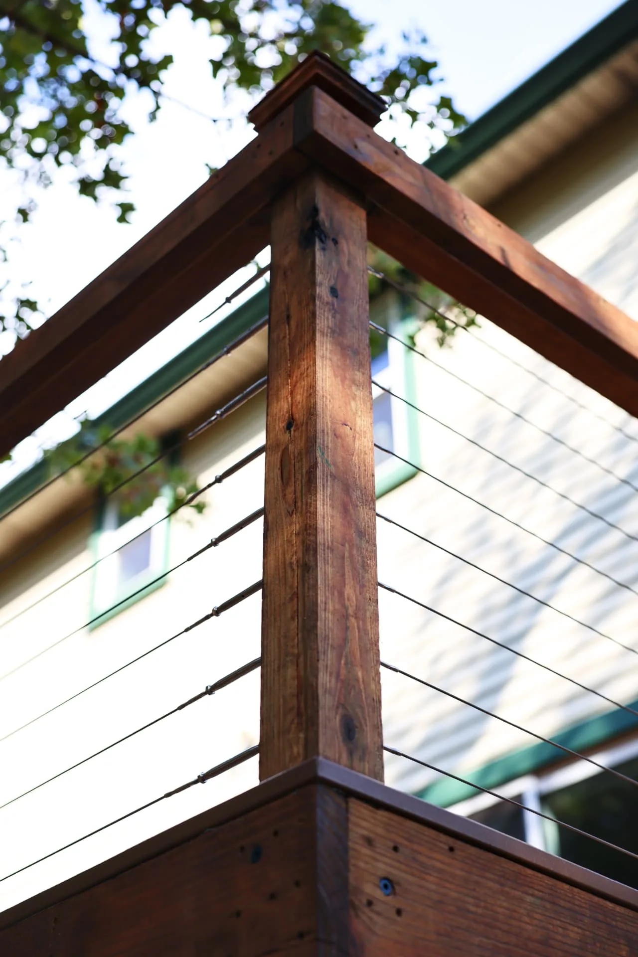Close-up of a stained post cap and cable railing corner detail