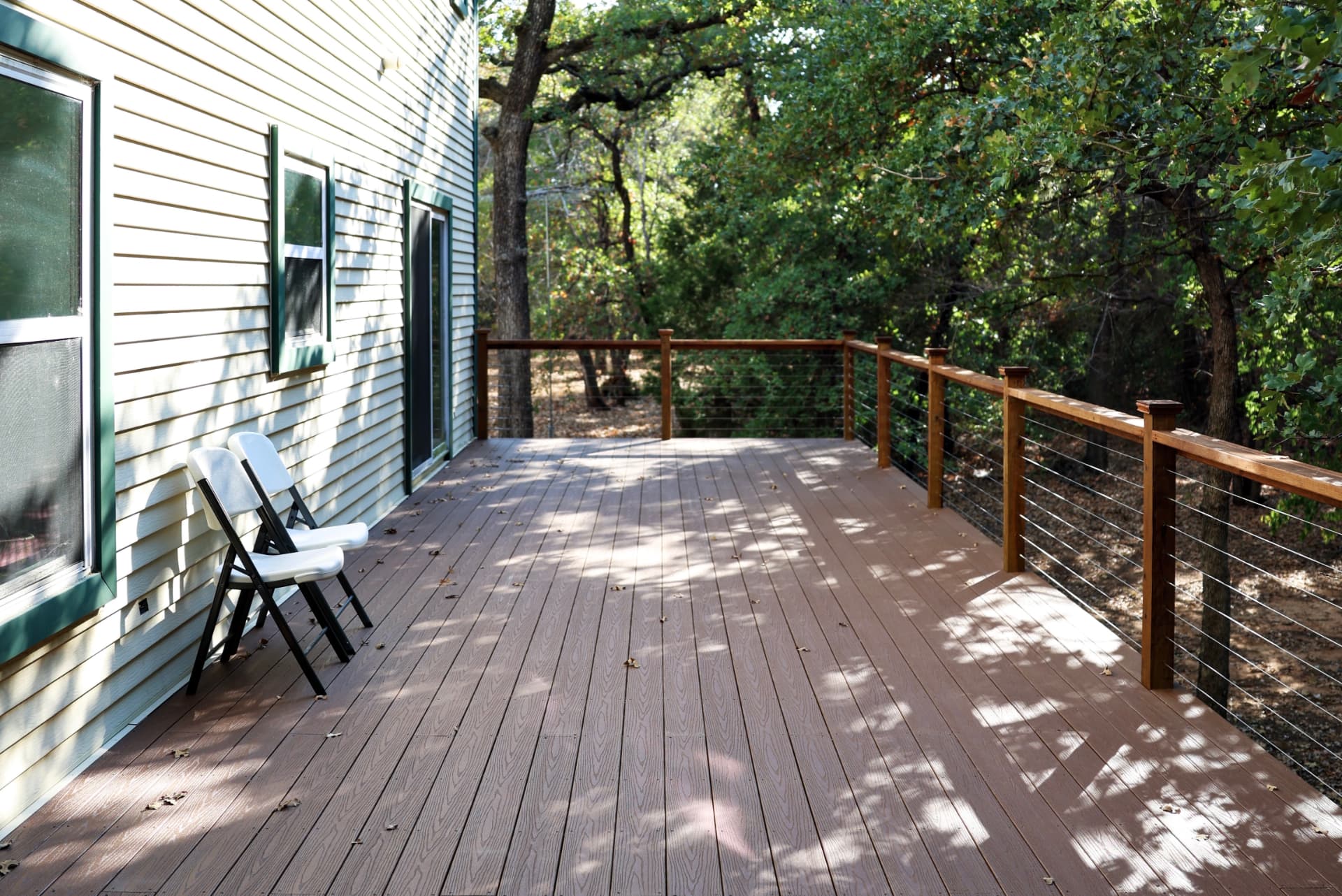 Composite deck surface and cable railing overlooking the tree line