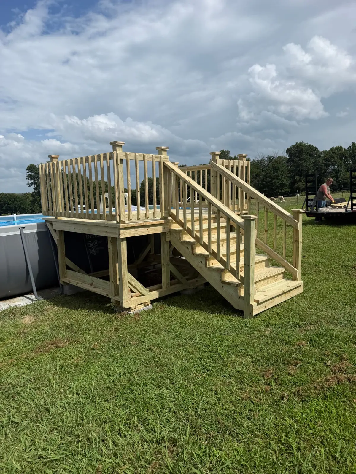Elevated above-ground pool deck with stairs and handrail