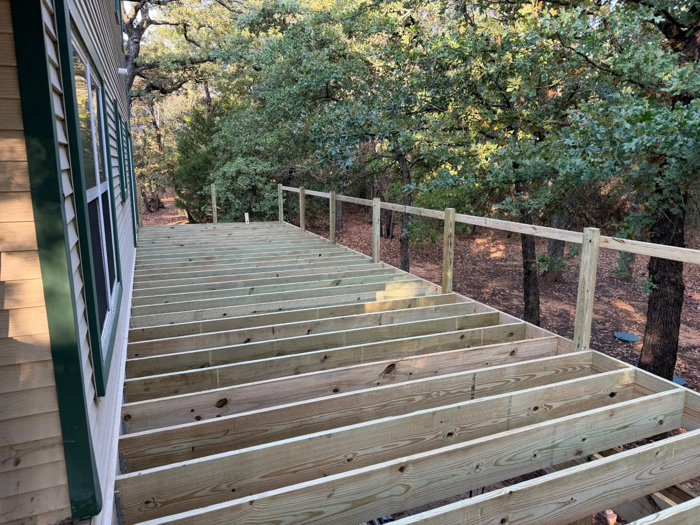 Deck joists and rail posts installed along the back of Greg's Grandview, TX home, ready for composite decking