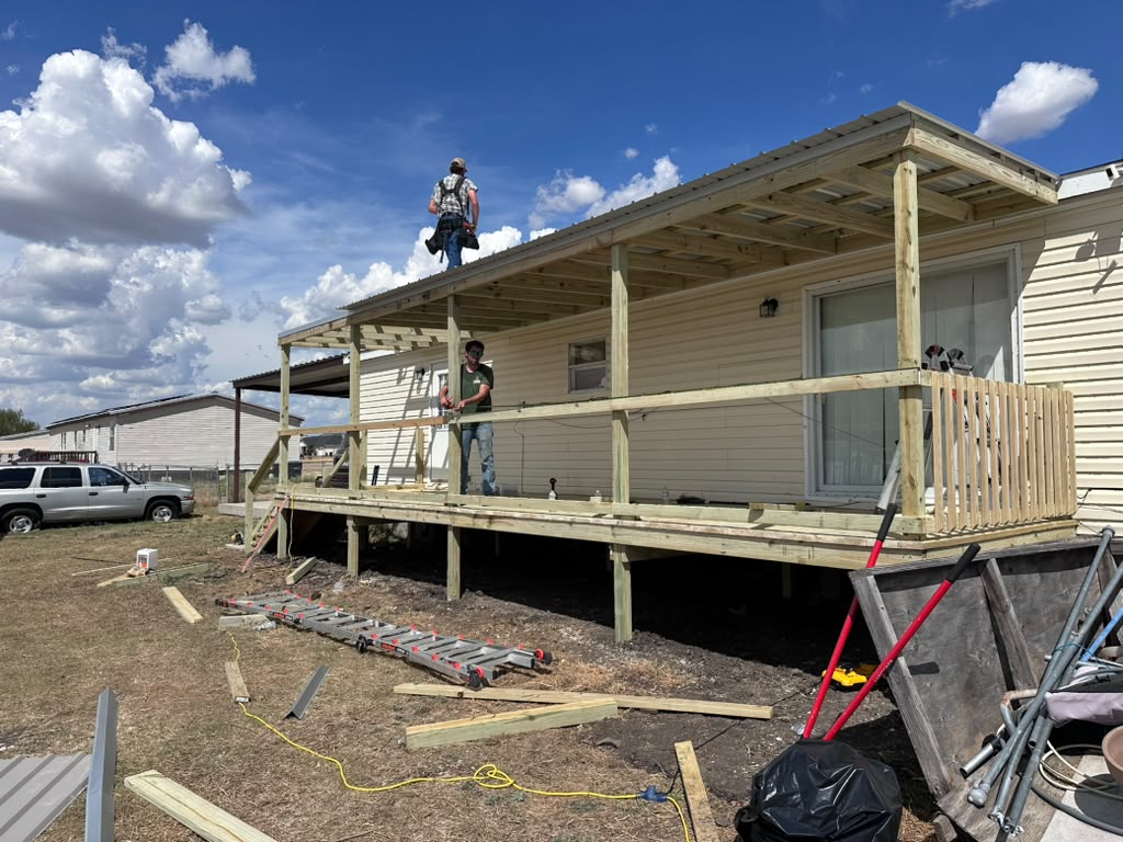 Metal roof panels and railings being installed on Violet's new covered deck in Joshua, TX