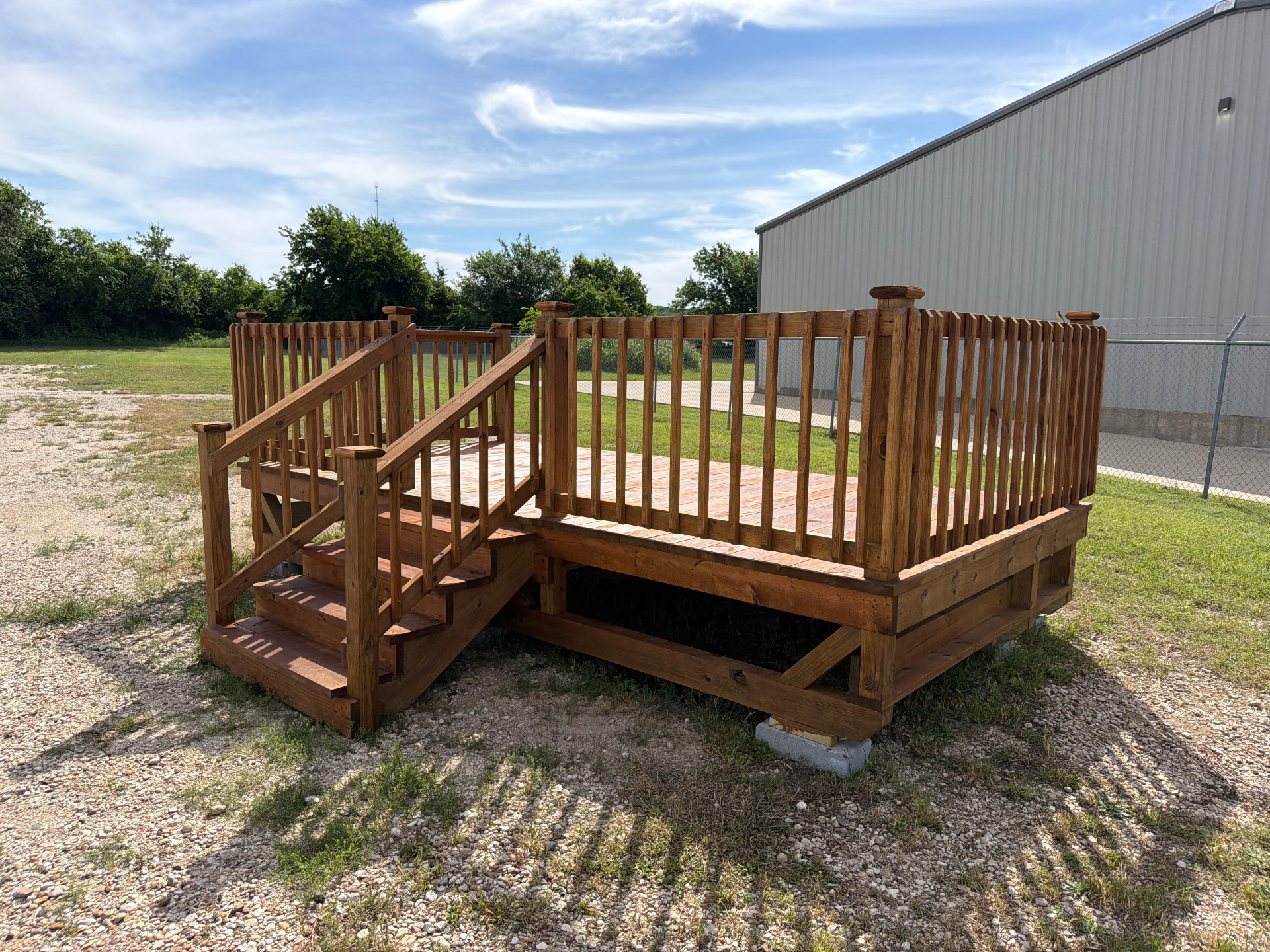 Custom pressure-treated pine deck with railing and stairs built by BenchMark Decks