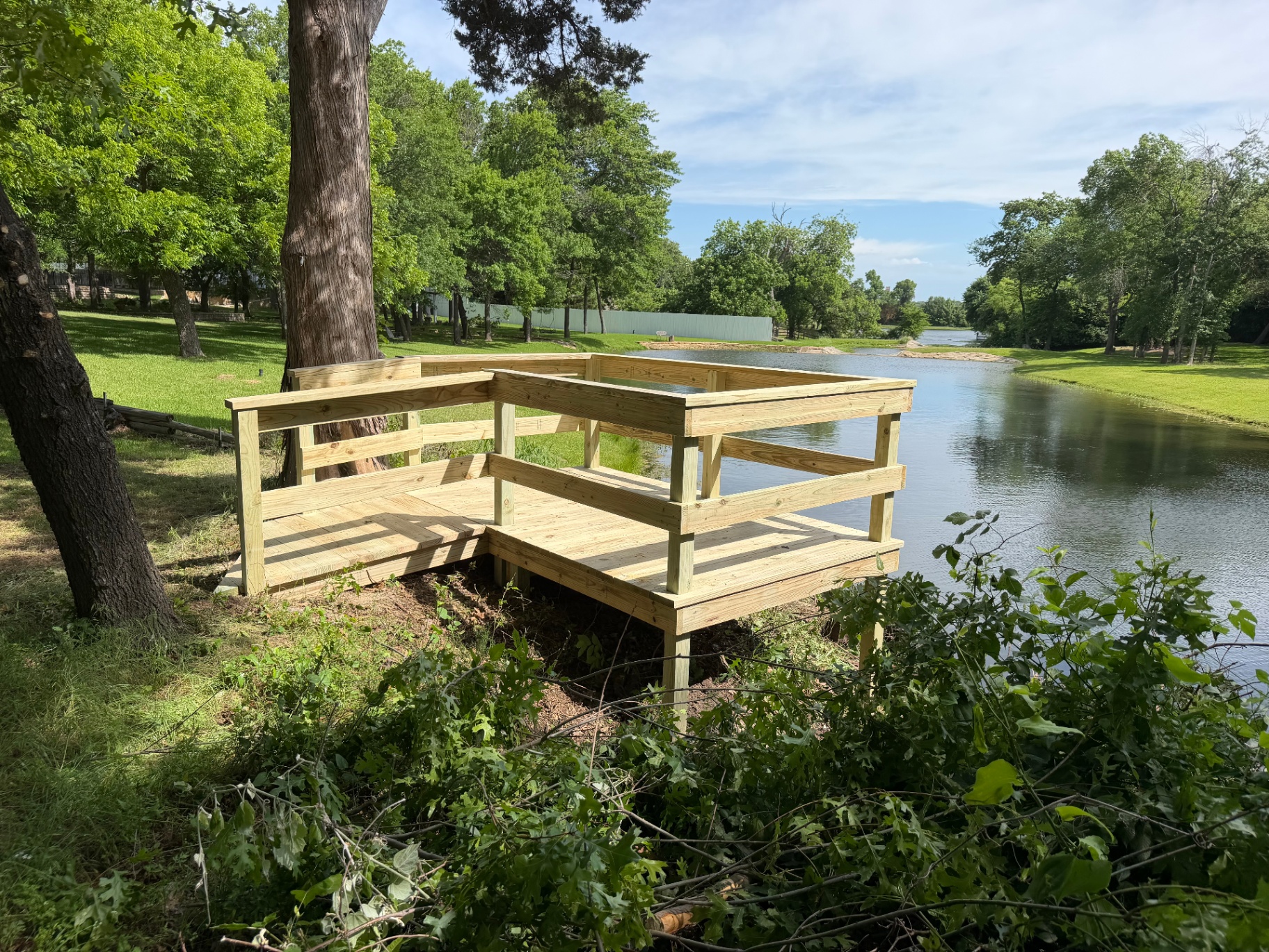 Custom pine deck overlooking pond with railing built by BenchMark Decks in Texas